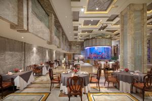 a restaurant with tables and chairs and a large aquarium at Crowne Plaza Shanghai Nanjing Road by IHG in Shanghai