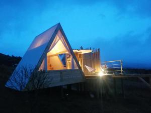 een klein huis met een blauw dak in een veld bij Andes Glamping in Guatavita