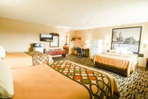 a hotel room with two beds and a flat screen tv at Super 8 by Wyndham McLean/Bloomington SW in McLean