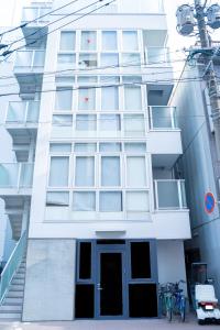 Biały budynek z rowerem zaparkowanym przed nim w obiekcie HOTEL ORIGO HAKATA - Gion - w mieście Fukuoka