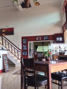 - une salle à manger avec une table et des chaises en bois dans l'établissement Route 76 Guest House, à Saen Monourom