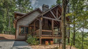 a cabin in the woods with a wrap around porch at Unplug in Ellijay