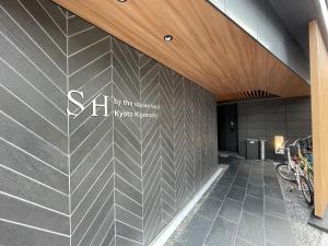 京都的住宿－SH by the square hotel Kyoto Kiyamachi，墙上有标志的建筑的大堂