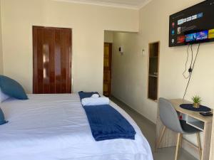 a bedroom with a bed with a tv on the wall at iMpongo Royal Lodge in Richards Bay