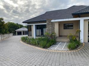 a house with a brick driveway in front of it at iMpongo Royal Lodge in Richards Bay