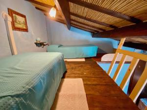 ein Schlafzimmer mit einem Etagenbett und einem blauen Sofa in der Unterkunft Domos Antigas in Bottidda