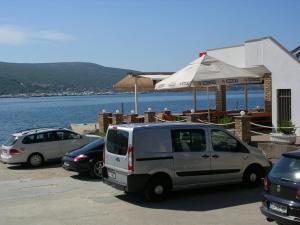 a white van parked in a parking lot next to the water at Apartment Perkovic Jadranka in Kornić