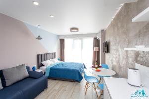 a bedroom with a bed and a couch and a table at Your Beach Tower in Batumi