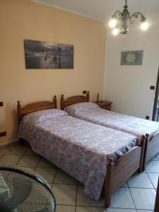 1 Schlafzimmer mit 2 Betten und einem Kronleuchter in der Unterkunft Bed & breakfast Mezzaluna in Feletto