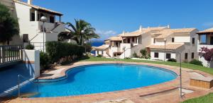 una piscina frente a una casa en Beach view apartment of 87 m2, big terrace, en Cala Murada