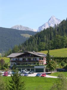 a hotel with cars parked in a parking lot with mountains at Apartment - Ferienwohnung Elisabeth in Radstadt