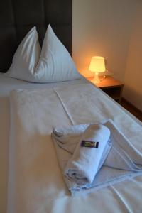 białe łóżko z ręcznikami i lampą w obiekcie Apartment - Ferienwohnung Elisabeth w mieście Radstadt