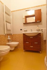 ein Badezimmer mit einem Waschbecken, einem WC und einem Spiegel in der Unterkunft Il Rifugio di Giada e Mattia in Alberobello