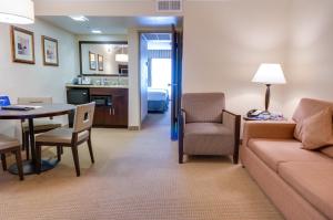 a living room with a couch and a table at Buena Park Grand Hotel & Suites in Buena Park
