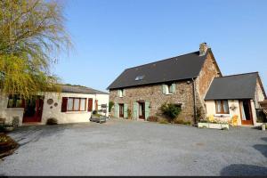 a large brick house with a driveway in front of it at Maison au pied des dunes, 200m de la plage in Montmartin-sur-Mer