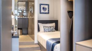 a small bedroom with a bed and a kitchen at Heritage Collection on Boat Quay - Quayside Wing - A Digital Hotel in Singapore