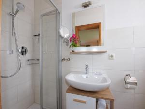 a white bathroom with a sink and a shower at Beim Dobler in Höslwang