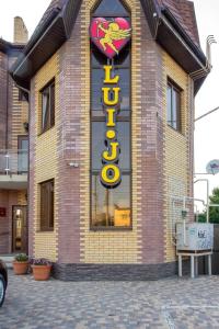 a building with a neon sign on the side of it at Villa LUI-JO in Krasnodar
