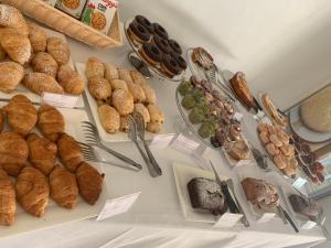 a table filled with different types of bread and pastries at Ganimede Hotel in Sperlonga