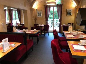 a dining room with tables and red chairs in a restaurant at Villa Augeval Hôtel de charme & Spa in Deauville