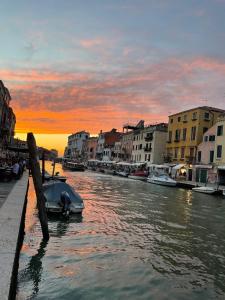 een boot is aangemeerd in een kanaal bij zonsondergang bij Ca' Bonfadini Historic Experience in Venetië