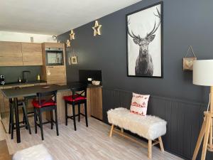 a kitchen and dining room with a table and a deer picture on the wall at Praloup 1600 t3 sur piste 4p in Uvernet-Fours
