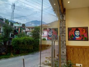 ein Fenster eines Gebäudes mit Straßenblick in der Unterkunft Hotel Nature's View in Dharamshala