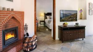 a living room with a brick fireplace and a bedroom at Casale Panayiotis in Kalopanayiotis