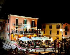 a group of tables with umbrellas in front of a building at Hotel Moderno Restaurant in Serina