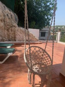 a rattan chair sitting on a patio at Es Cucó in Cala Galdana