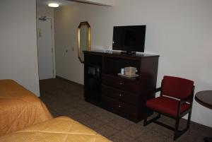 a hotel room with a television and a bed at Clinton Inn & Suites in Port Clinton