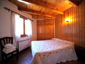 um quarto com uma cama num quarto de madeira em Apartament L'àtic em Espot