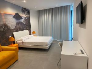 a bedroom with a bed and a tv and a couch at Torre del mare Rooms in Bergeggi