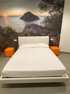 a bed in a room with a painting of the ocean at Torre del mare Rooms in Bergeggi
