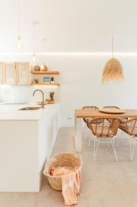 een keuken met een tafel en stoelen en een wastafel bij Apartamento Las Golondrinas Arenal - Adults Only in Arenal d'en Castell