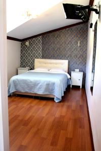 Schlafzimmer mit einem Bett und Holzboden in der Unterkunft Nizam Butik Otel Büyükada in Büyükada