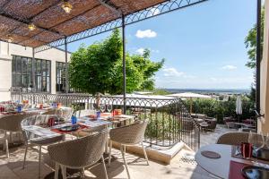 - un restaurant avec une table et des chaises sur la terrasse dans l'établissement Hotel La Mère Germaine, à Châteauneuf-du-Pape