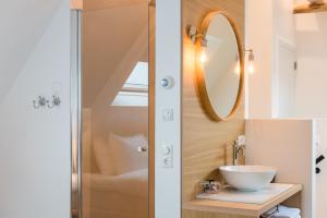 a bathroom with a sink and a mirror at Fietshotel Zee van Tijd Holwerd in Holwerd +24 photos