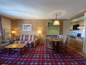 ein Wohnzimmer mit Sofa und Tisch in der Unterkunft Arc 1950 - Résidence Hameau du Glacier in Bourg-Saint-Maurice