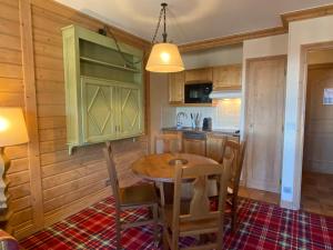 eine Küche mit einem Holztisch und Stühlen in der Unterkunft Arc 1950 - Résidence Hameau du Glacier in Bourg-Saint-Maurice + 3 Fotos