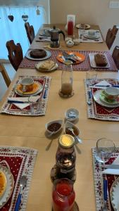 una mesa larga con platos de comida. en B&B al Capitello, en Trento