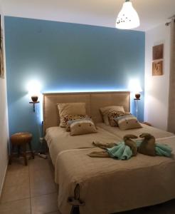 una camera con un grande letto con una parete blu di Maison Bouzigues a Bouzigues