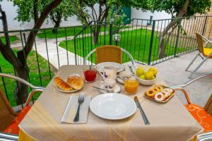 a table with a breakfast of croissants and orange juice at Hotel Soleo in Quartu SantʼElena