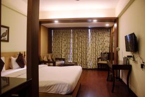 a hotel room with two beds and a window at Savoy Greens Jabli in Kasauli