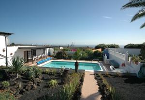 a villa with a swimming pool and a house at Finca el Volcan in Mácher