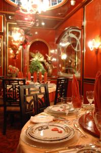 ein Esszimmer mit einem Tisch mit Tellern und Weingläsern in der Unterkunft Regency Palace Hotel in Jounieh