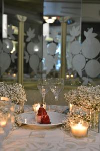 einen Tisch mit einem Teller mit Essen, Gläsern und Kerzen in der Unterkunft Regency Palace Hotel in Jounieh