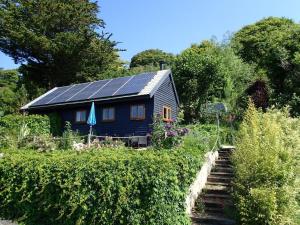 a blue house with solar panels on the roof at Rose Lodge in Aller