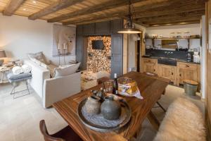 Le BiotL'Ours Blanc Lodge的厨房以及带木桌的起居室。