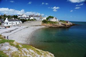 a view of a beach with houses and the water at CYNEFIN- 3 Bed, 2 Bath-1 x En-Suite, DETCAHED BUNGLAOW- PET FRIENDLY in Trearddur